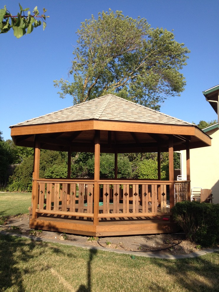 Cette photo montre une terrasse en bois arrière craftsman de taille moyenne avec un gazebo ou pavillon.