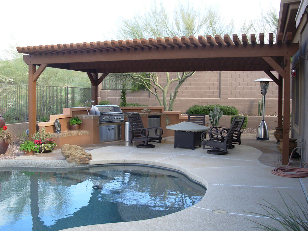 Foto di un grande patio o portico classico dietro casa con lastre di cemento e una pergola