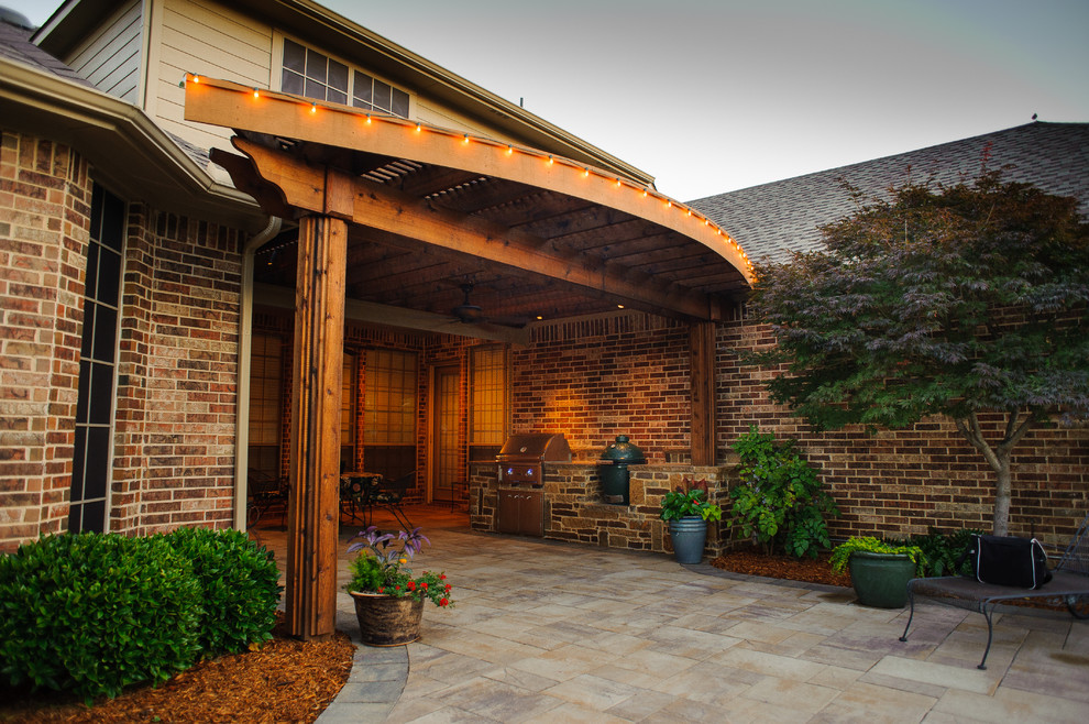 Esempio di un patio o portico american style di medie dimensioni e dietro casa con pavimentazioni in pietra naturale e un tetto a sbalzo