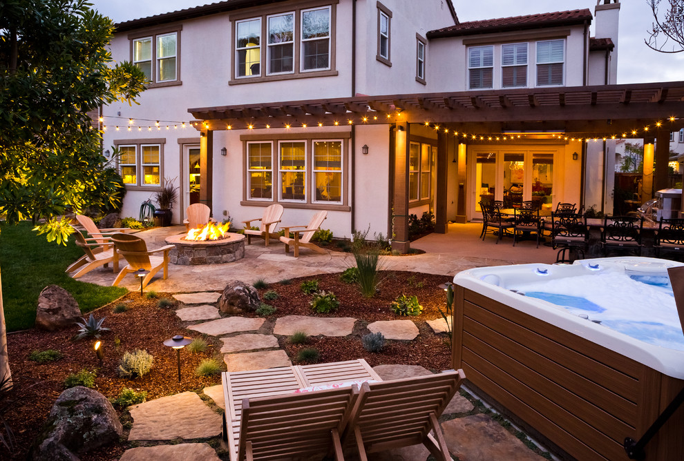 This is an example of a medium sized rustic back patio in San Francisco with a fire feature and natural stone paving.