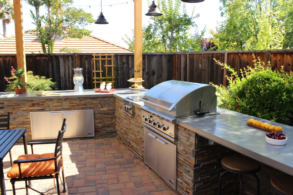 Photo of a large classic back patio in San Francisco with an outdoor kitchen, brick paving and a pergola.