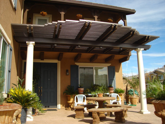 Ejemplo de patio tradicional de tamaño medio en patio delantero con adoquines de hormigón, pérgola y jardín de macetas