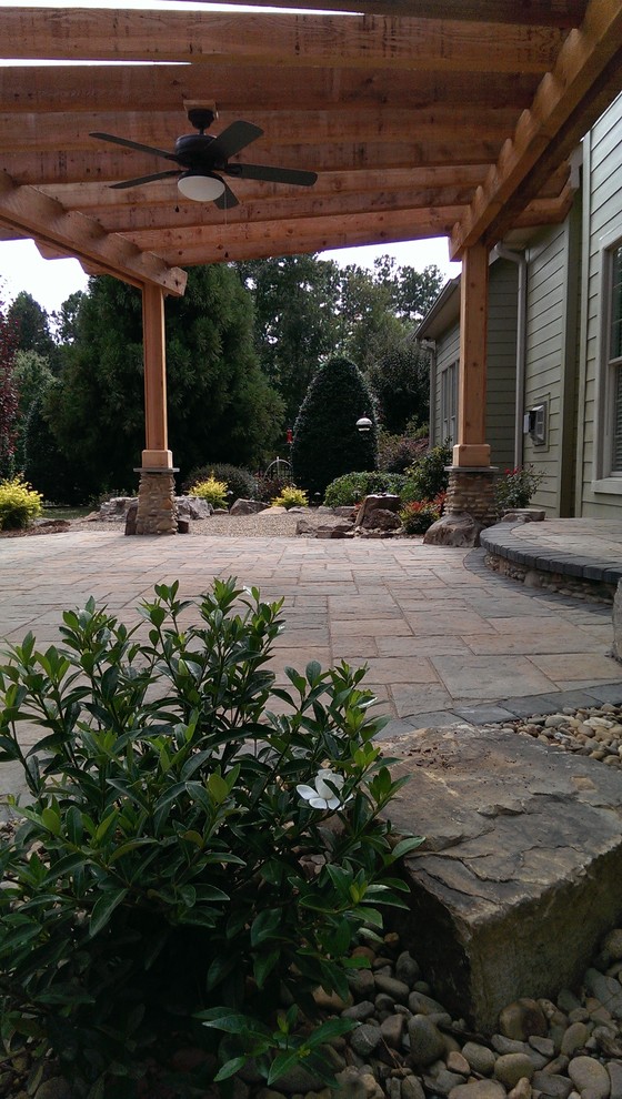 Medium sized classic back patio in Charlotte with a fire feature, concrete paving and a pergola.