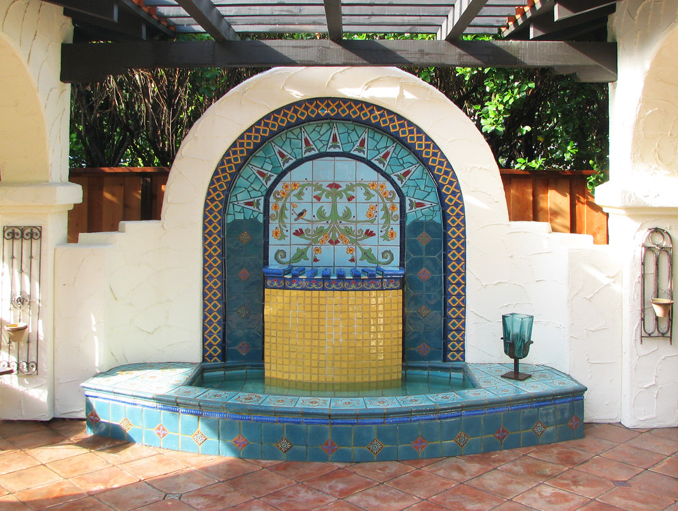 Foto på en medelhavsstil uteplats, med en fontän och kakelplattor