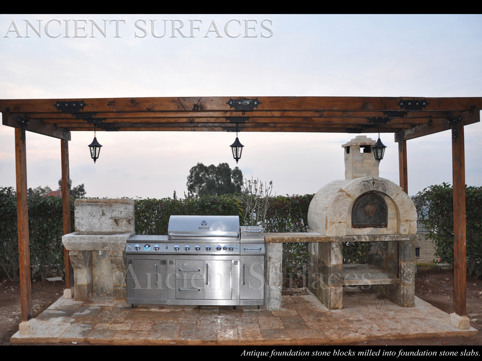 Imagen de patio mediterráneo de tamaño medio en patio trasero con cocina exterior, adoquines de piedra natural y pérgola