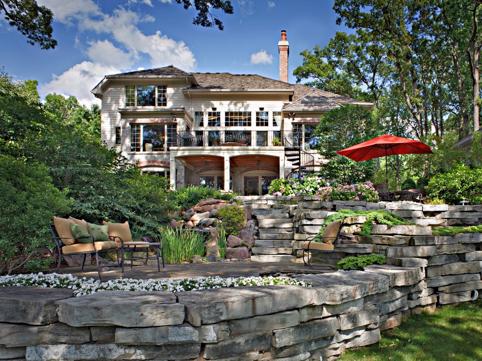 Immagine di un patio o portico tradizionale di medie dimensioni e dietro casa con fontane, pavimentazioni in mattoni e un tetto a sbalzo