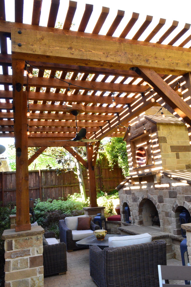 Foto di un patio o portico mediterraneo di medie dimensioni e dietro casa con un focolare, pavimentazioni in pietra naturale e una pergola