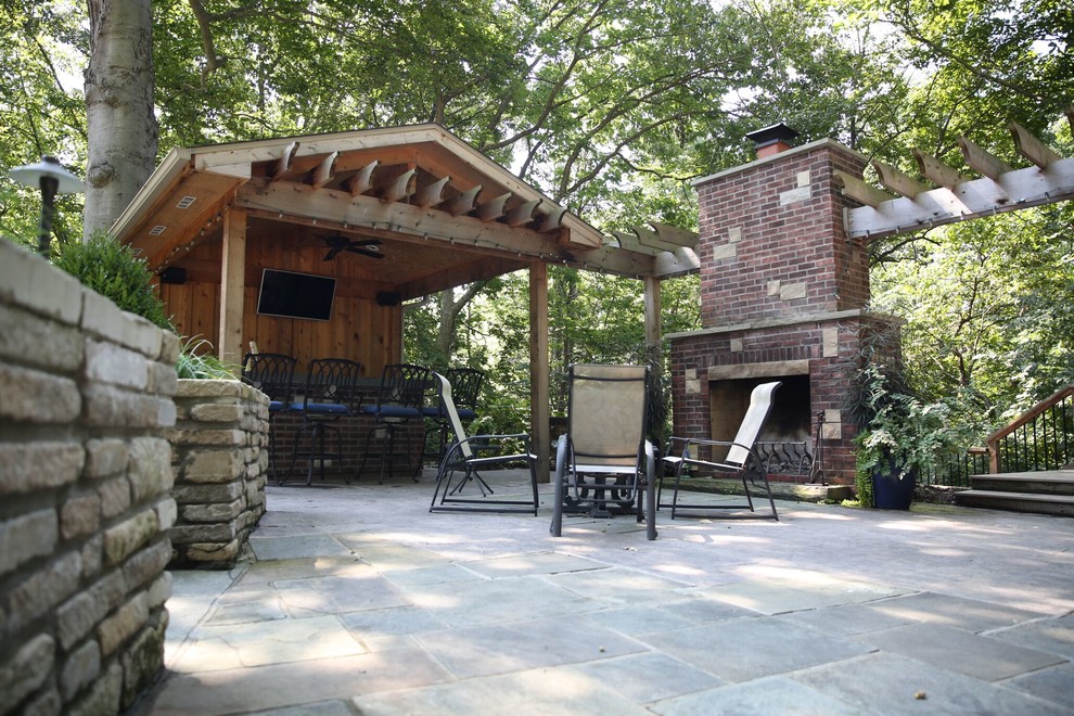 Immagine di un patio o portico rustico con piastrelle e una pergola
