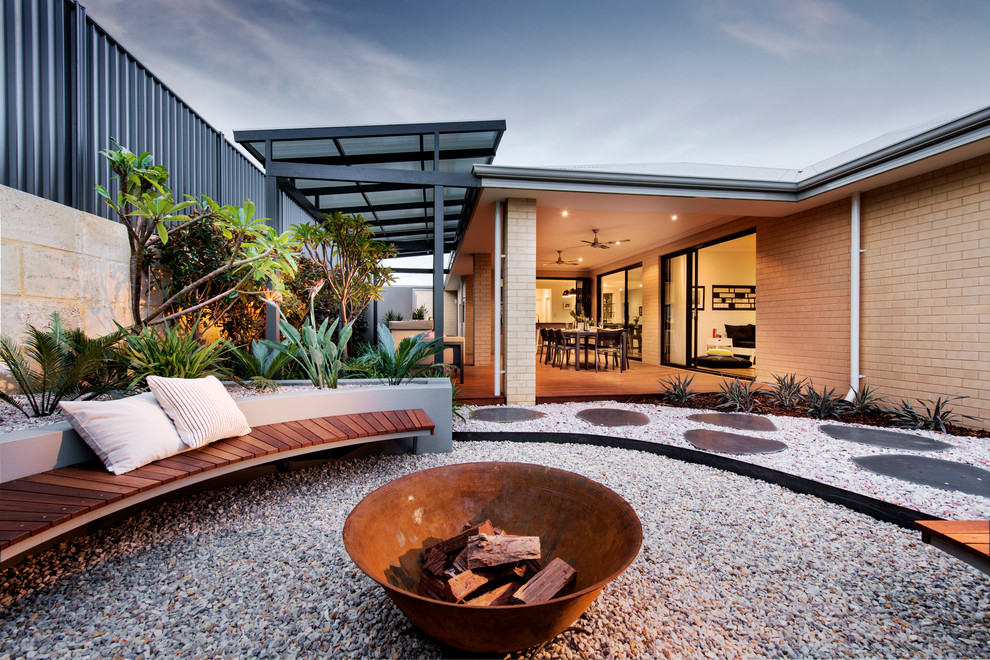 Großer Moderner Patio mit Kies hinter dem Haus mit Feuerstelle in Perth