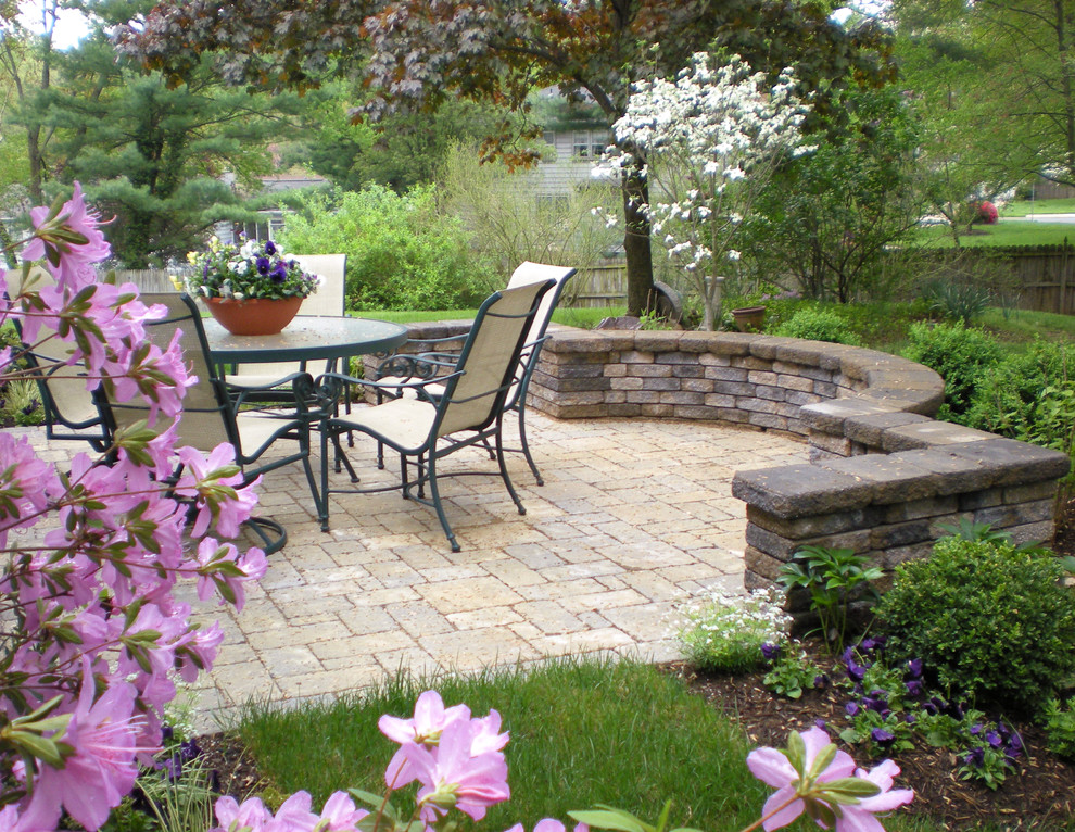 Example of a mid-sized classic backyard concrete paver patio design in DC Metro with no cover