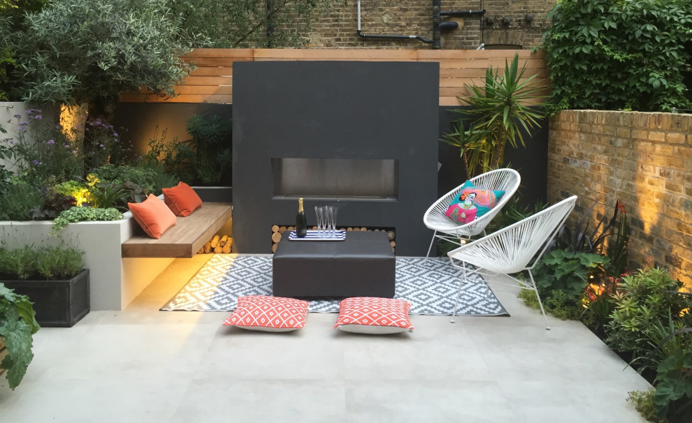 Small contemporary courtyard patio with a fireplace, tiled flooring and no cover.
