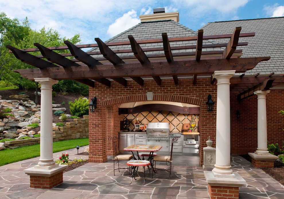 Idées déco pour une terrasse arrière classique de taille moyenne avec une cuisine d'été, du béton estampé et une extension de toiture.