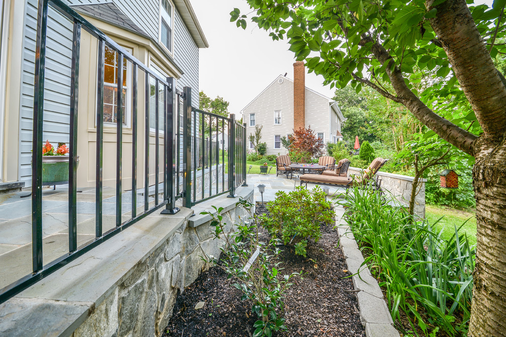 Esempio di un patio o portico design dietro casa con pavimentazioni in pietra naturale e nessuna copertura
