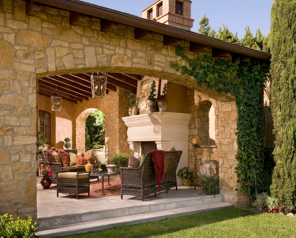 Patio - large french country backyard patio idea in Orange County with a fire pit and a roof extension
