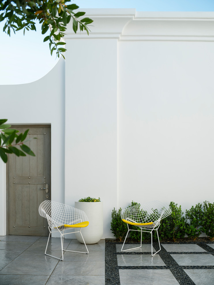 Foto di un patio o portico mediterraneo di medie dimensioni e dietro casa con piastrelle e nessuna copertura