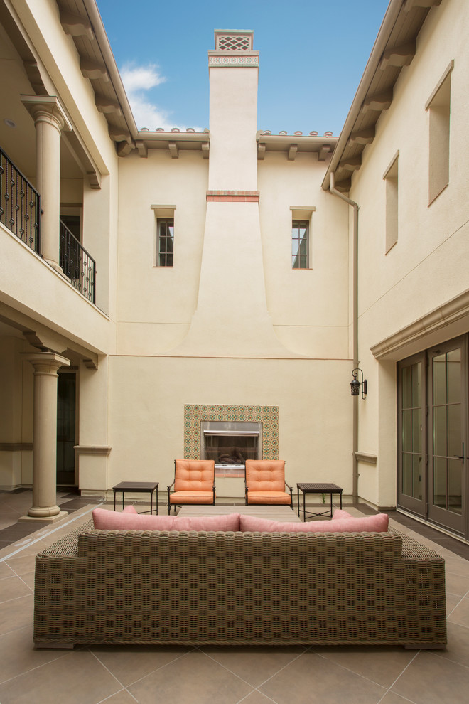 Свежая идея для дизайна: двор на внутреннем дворе в средиземноморском стиле с покрытием из плитки и уличным камином без защиты от солнца - отличное фото интерьера