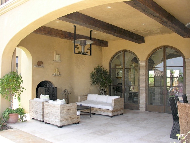 Idée de décoration pour une grande terrasse arrière craftsman avec un foyer extérieur, du carrelage et une extension de toiture.