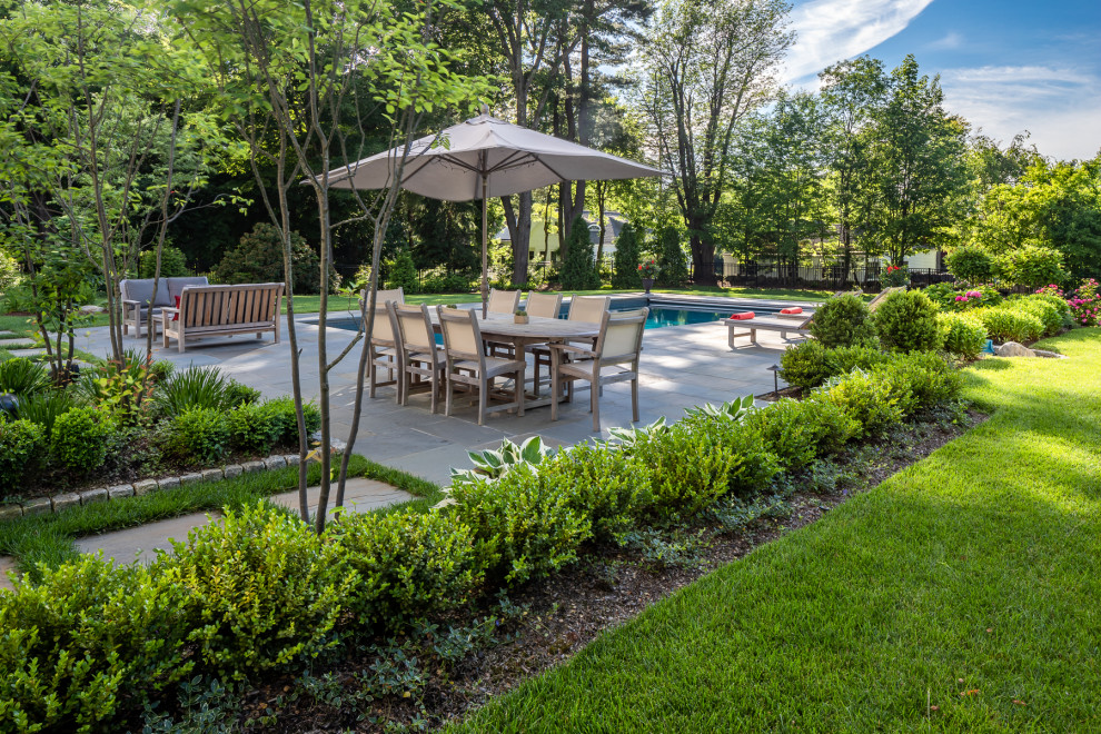 Inspiration for a large contemporary backyard stone patio remodel in Boston with no cover