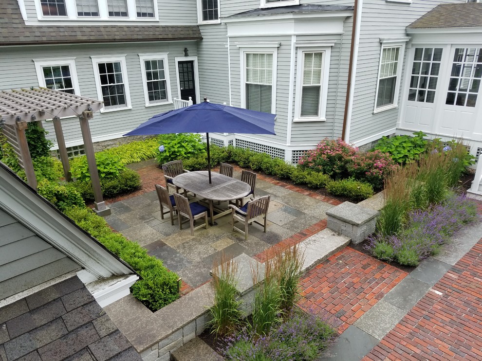 Diseño de patio tradicional de tamaño medio en patio trasero con jardín vertical, adoquines de ladrillo y pérgola