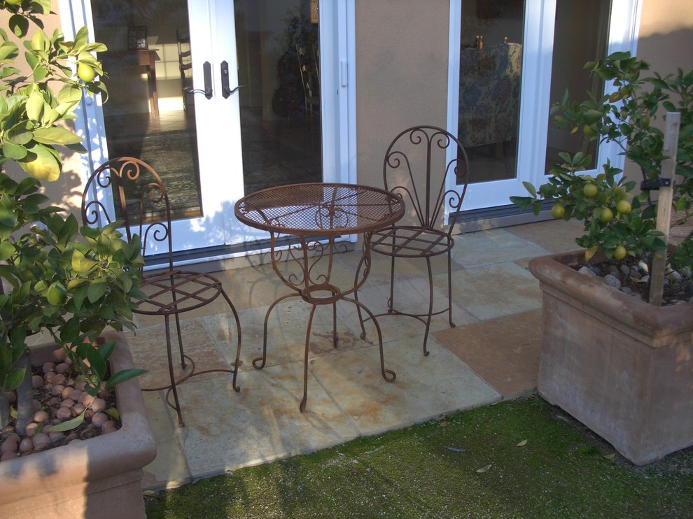 This is an example of a large traditional side patio in San Francisco with a potted garden and natural stone paving.