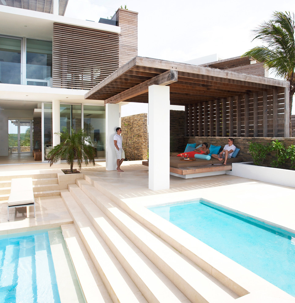Foto di un grande patio o portico tropicale dietro casa con una pergola