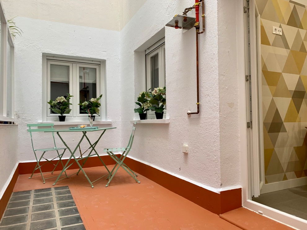 Design ideas for a medium sized contemporary back patio in Madrid with tiled flooring.