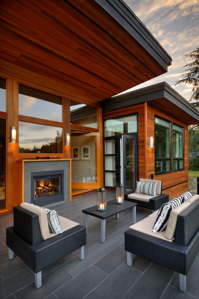 Idée de décoration pour une terrasse design avec un foyer extérieur.