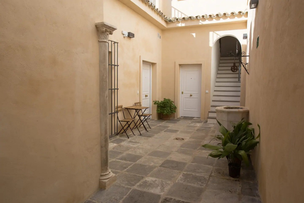 Cette photo montre une petite terrasse éclectique avec une cour et des pavés en pierre naturelle.