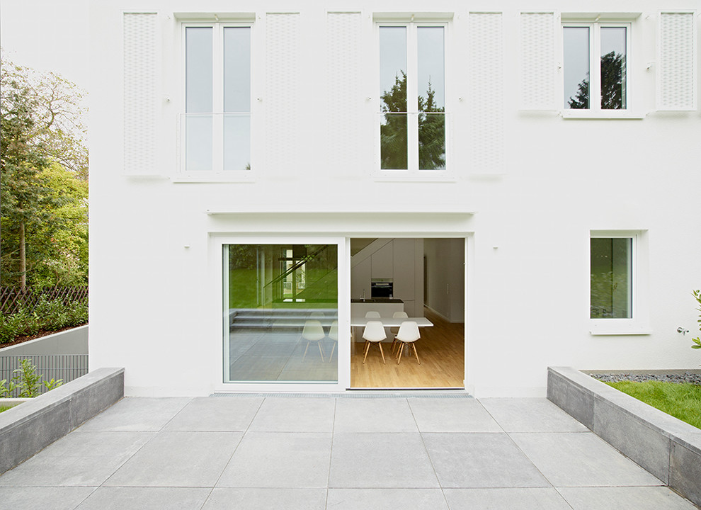 Inspiration for a medium sized modern back patio in Frankfurt with concrete slabs.