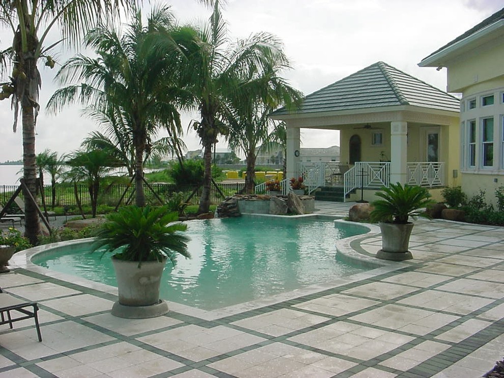 Example of a large trendy backyard concrete paver pool fountain design in Tampa