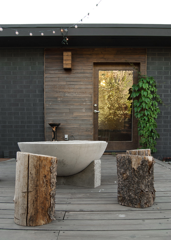 Idée de décoration pour une terrasse en bois arrière design de taille moyenne avec un foyer extérieur et aucune couverture.
