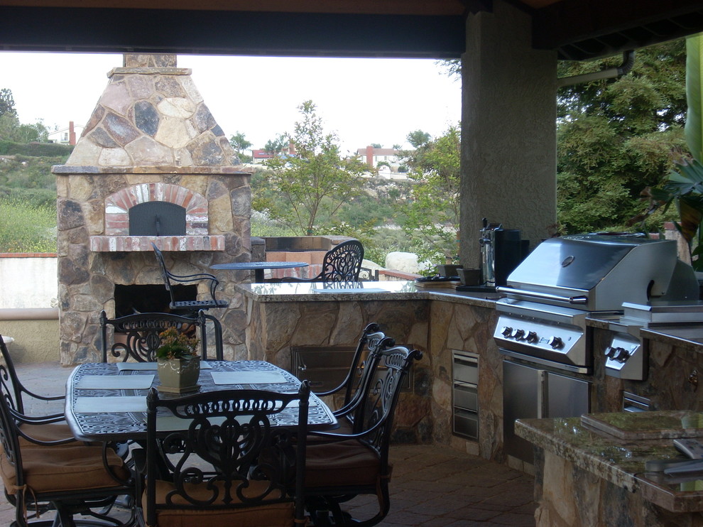 Imagen de patio tradicional grande en patio trasero con cocina exterior, adoquines de piedra natural y cenador