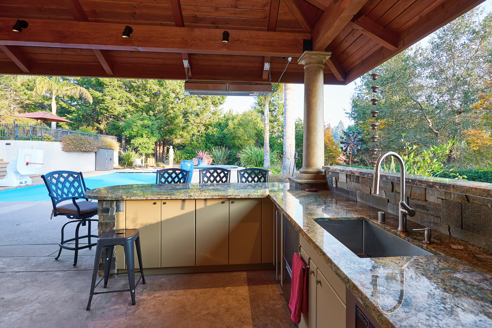 This is an example of a large classic back patio in Other with an outdoor kitchen, stamped concrete and a gazebo.