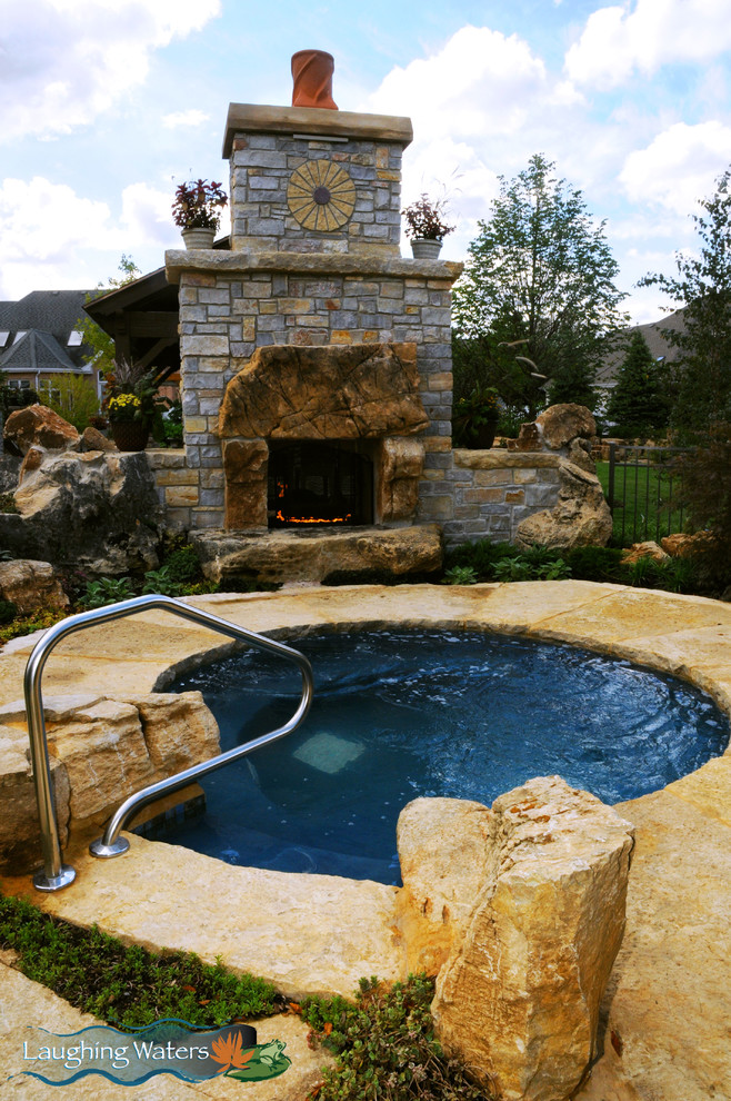 Cette image montre une grande terrasse arrière chalet avec une cuisine d'été, des pavés en pierre naturelle et aucune couverture.
