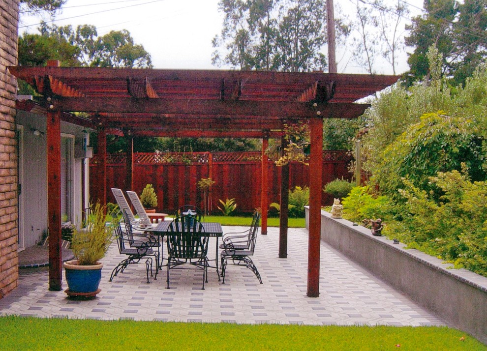 Ispirazione per un piccolo patio o portico contemporaneo dietro casa con pavimentazioni in cemento e una pergola