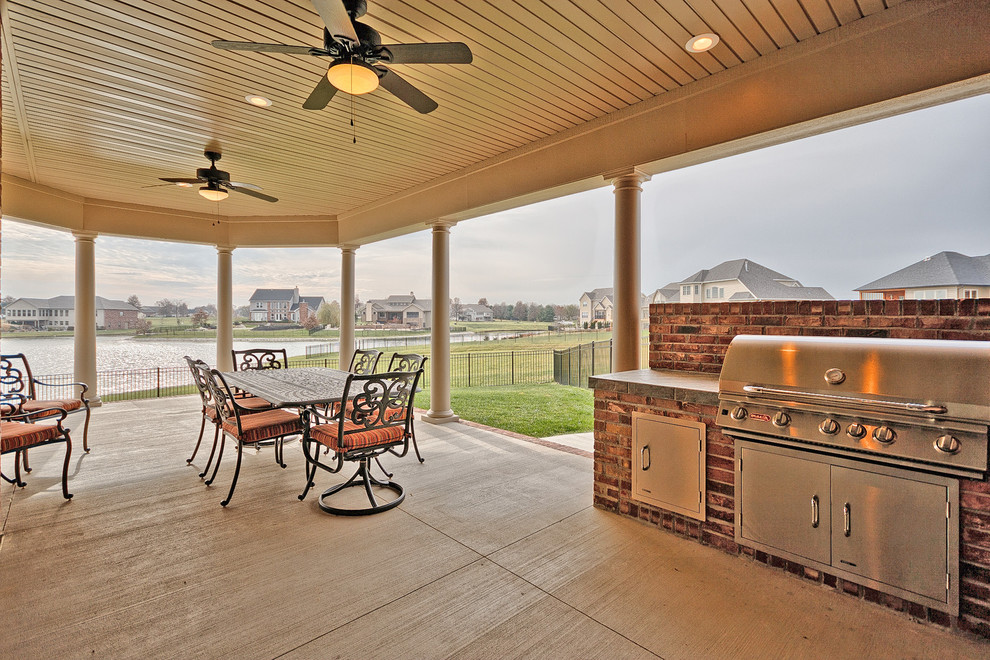 Idées déco pour une terrasse arrière classique de taille moyenne avec une cuisine d'été, une dalle de béton et un auvent.