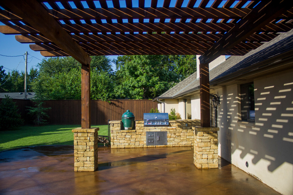 Foto de patio de estilo americano pequeño en patio trasero con cocina exterior, losas de hormigón y pérgola