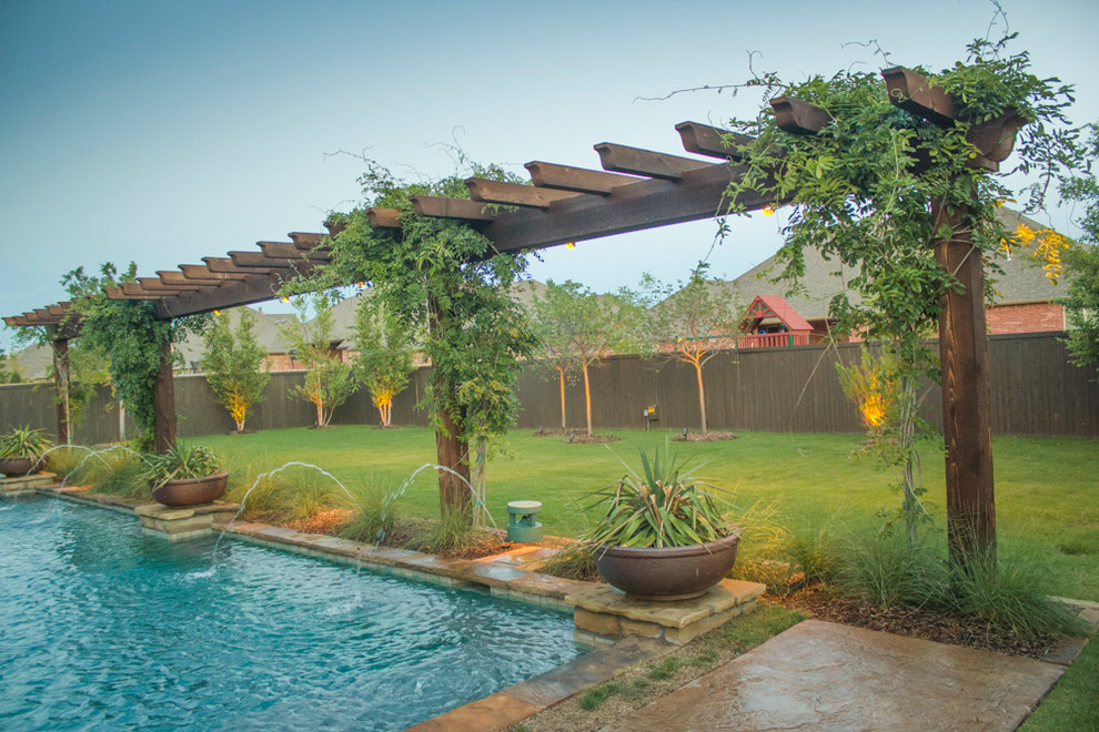 Diseño de patio de estilo americano de tamaño medio en patio trasero con fuente, adoquines de hormigón y pérgola