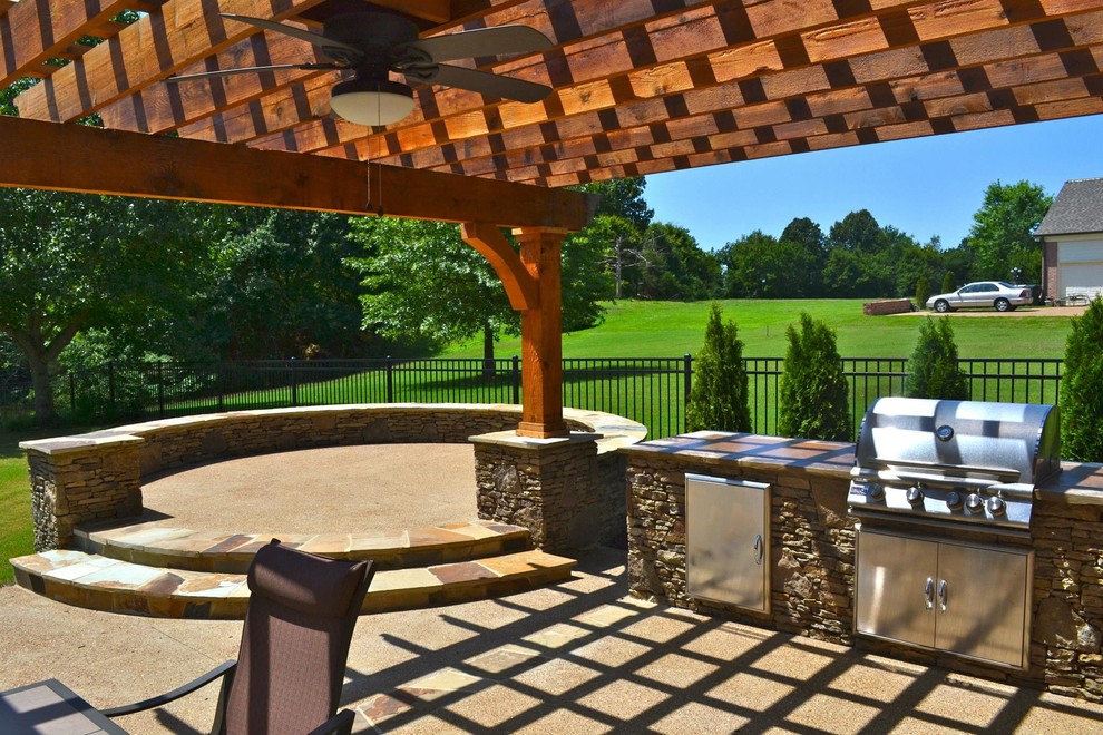 Exemple d'une terrasse arrière chic de taille moyenne avec une cuisine d'été, un gravier de granite et une pergola.
