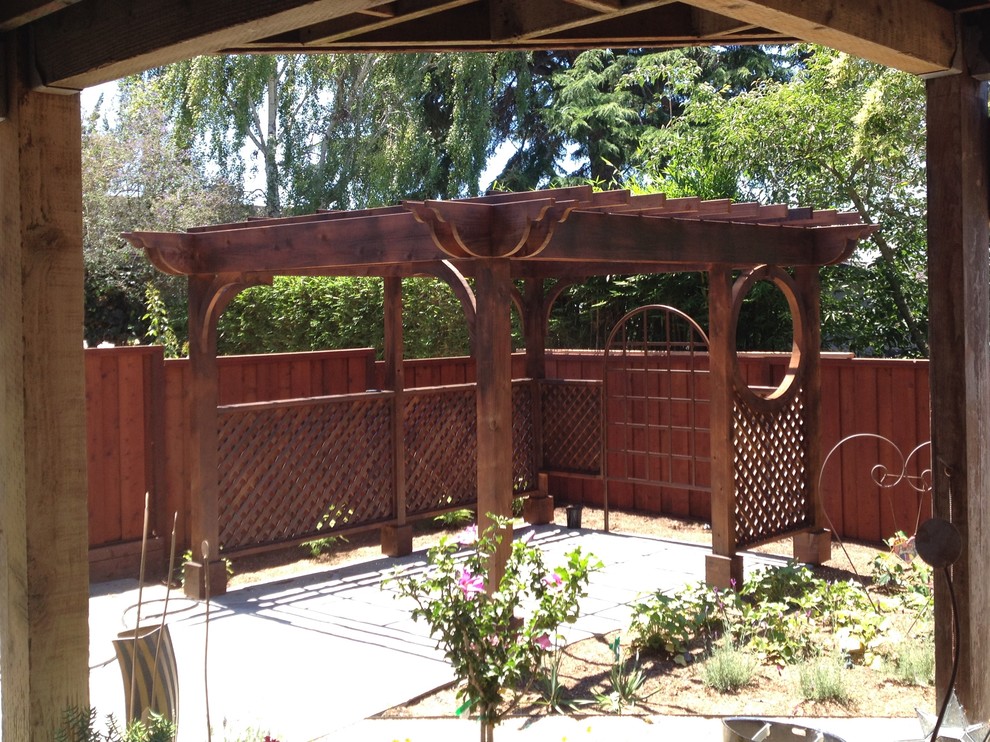 This is an example of a medium sized classic back patio in San Francisco with concrete paving and a pergola.