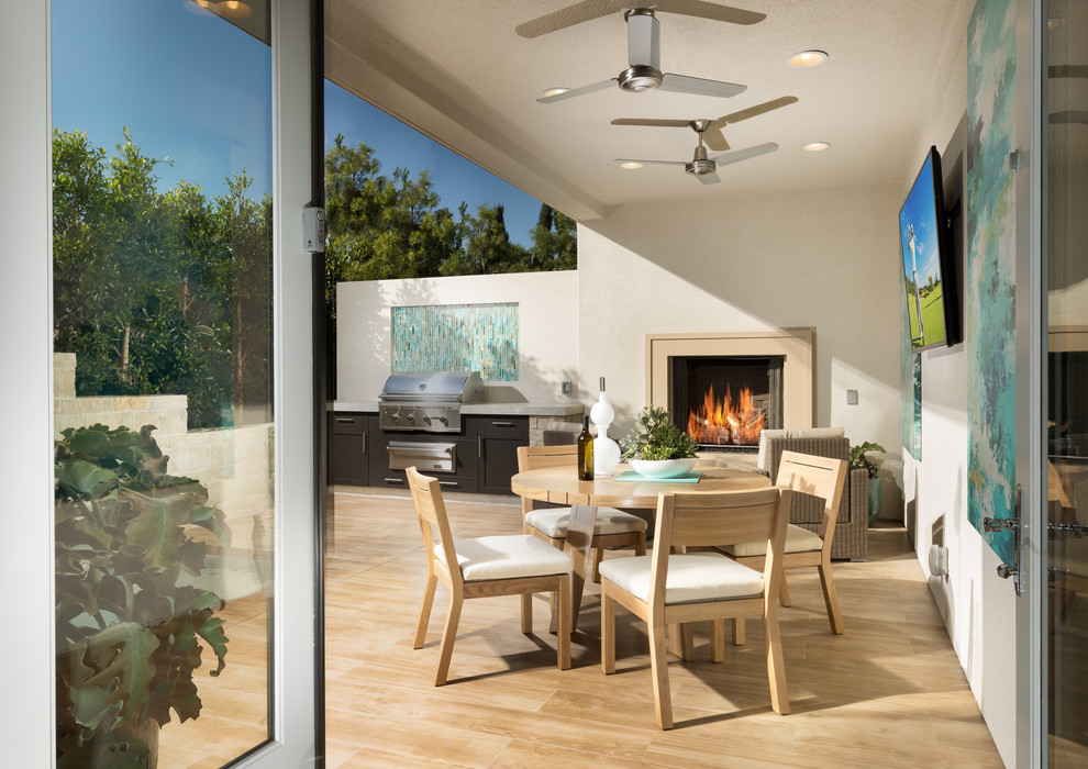 Inspiration for a large contemporary back patio in San Diego with a fireplace, tiled flooring and a roof extension.
