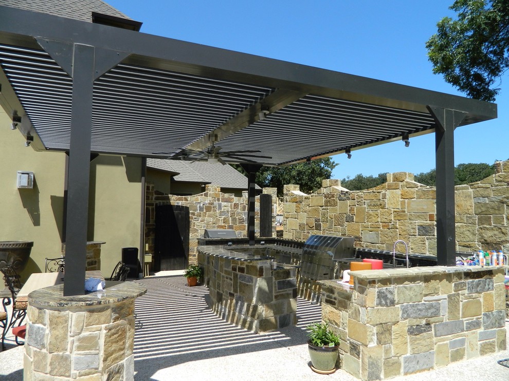 Example of a large minimalist backyard concrete patio kitchen design in Dallas with a pergola