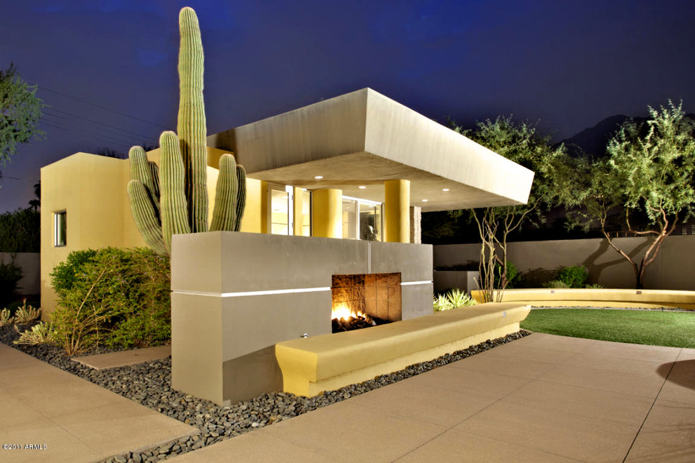 Inspiration for a huge modern backyard concrete patio remodel in Phoenix with a fire pit and a roof extension