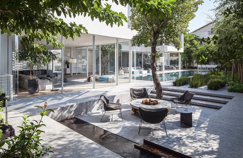 Стильный дизайн: огромный двор на заднем дворе в современном стиле с местом для костра и покрытием из плитки без защиты от солнца - последний тренд
