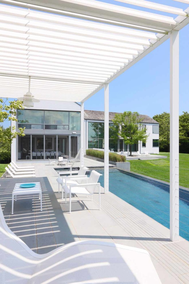 This is an example of a contemporary patio in New York with a pergola.