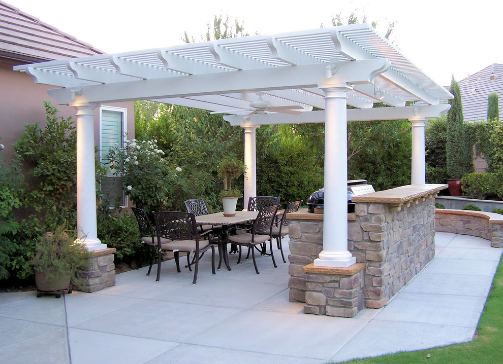 This is an example of a medium sized mediterranean back patio in Other with an outdoor kitchen, concrete slabs and a pergola.