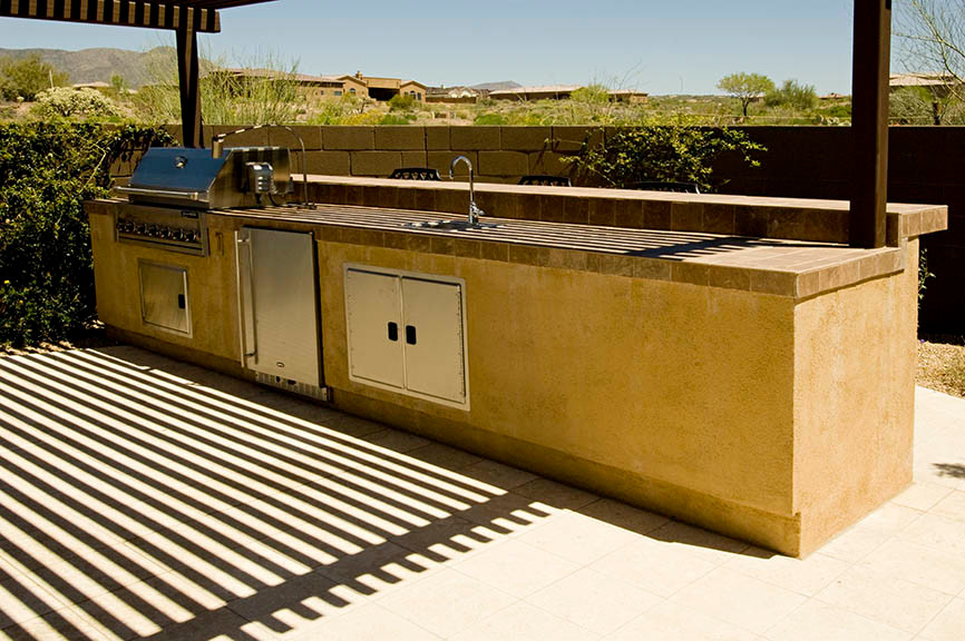 Foto de patio de estilo americano de tamaño medio en patio trasero con cocina exterior, adoquines de hormigón y pérgola