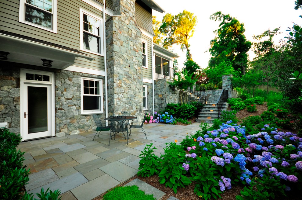 Example of a large classic backyard stone patio design in DC Metro with no cover