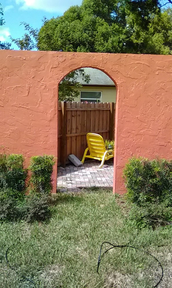Immagine di un patio o portico chic di medie dimensioni e dietro casa con pavimentazioni in cemento e nessuna copertura