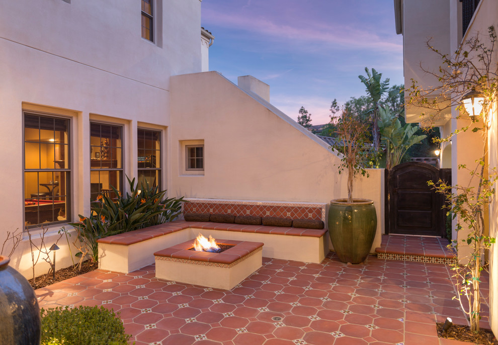 ロサンゼルスにあるラグジュアリーな広い地中海スタイルのおしゃれな中庭のテラス (ファイヤーピット、タイル敷き、日よけなし) の写真